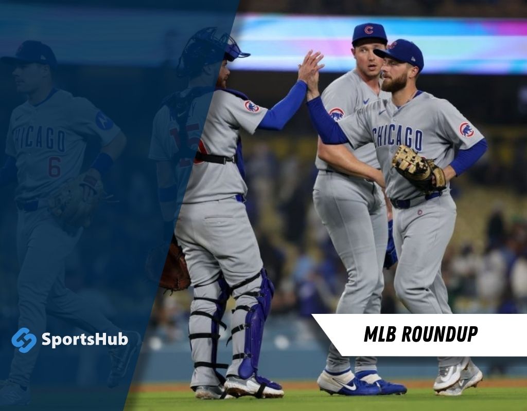 Chicago Cubs players celebrating on the field after a play, wearing gray jerseys with team logos during an MLB game night.