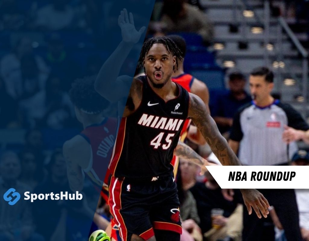 A Miami Heat player in a black jersey celebrates during an NBA game, with spectators and referees visible in the background.