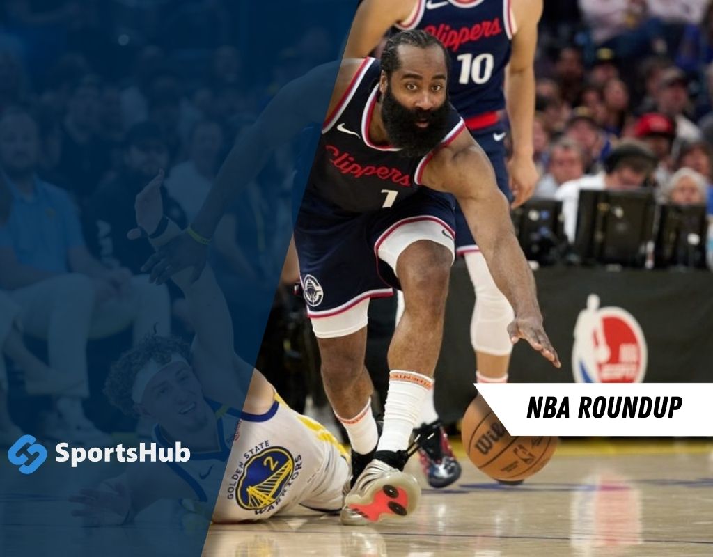 An NBA player in a Clippers uniform reaches for a loose basketball on the court amidst a vibrant game scene. SportsHub branding is visible.