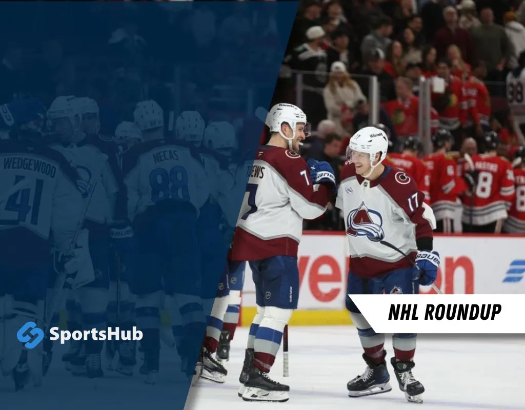 Two hockey players in Colorado Avalanche jerseys celebrate a moment during an NHL game, with fans cheering in the background.