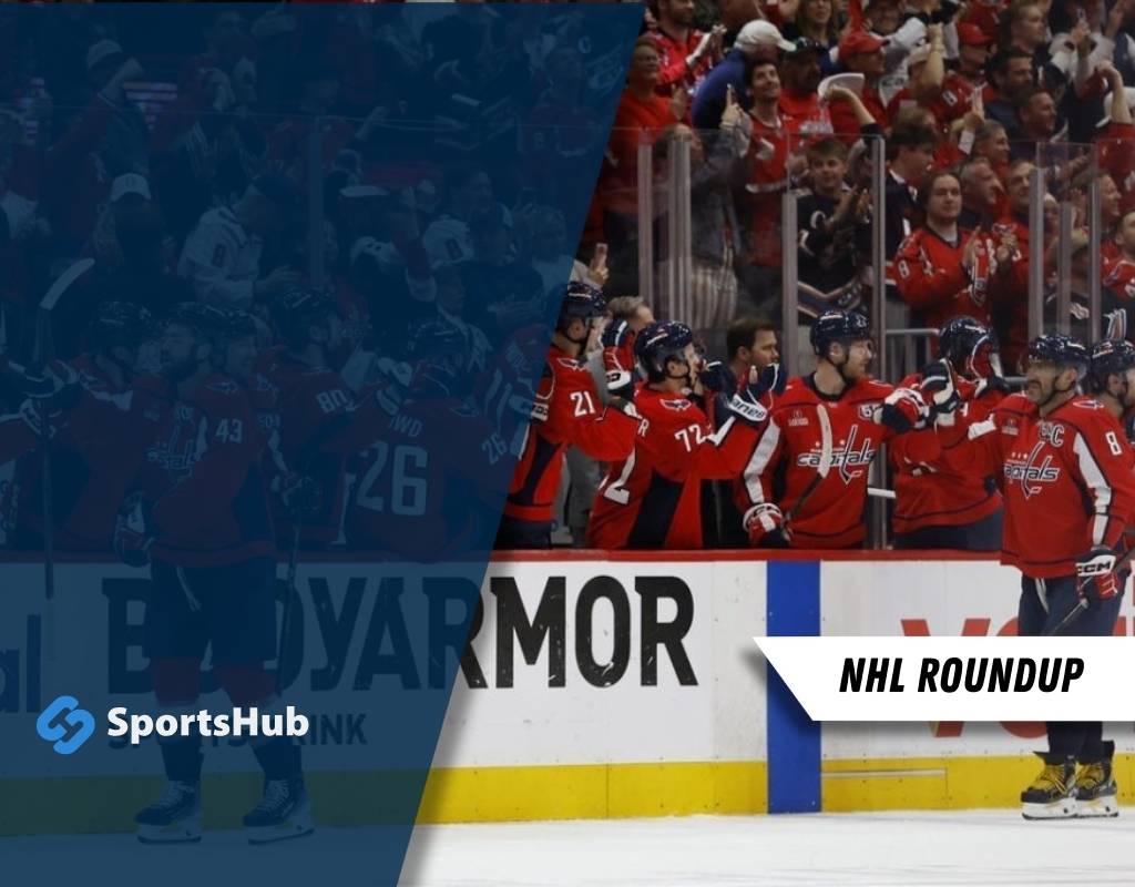 A group of hockey players in red jerseys celebrates on the bench during an NHL game, with fans cheering in the background.