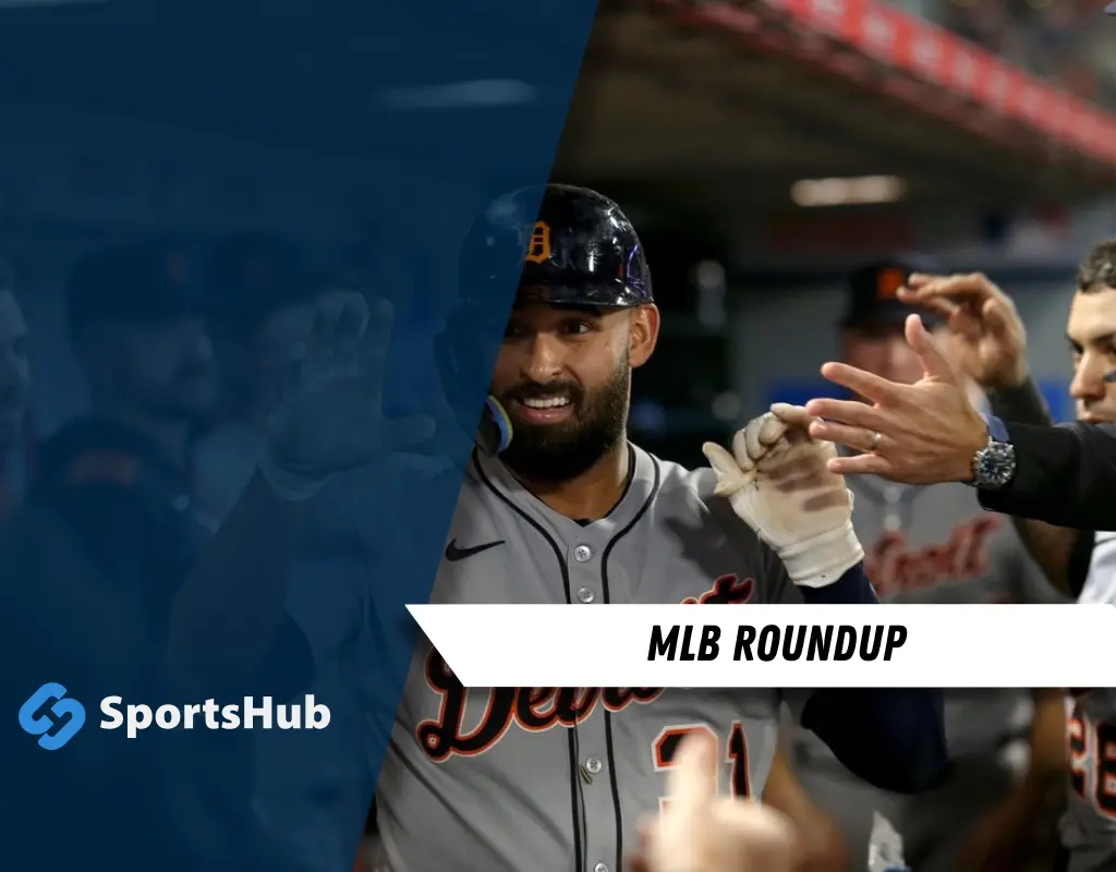 A smiling Detroit Tigers player is greeted by teammates in the dugout