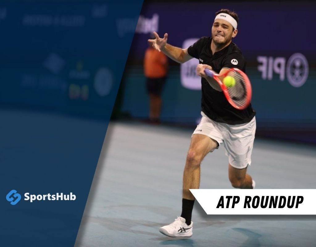 A tennis player in a black shirt executes a forehand shot on a blue court.