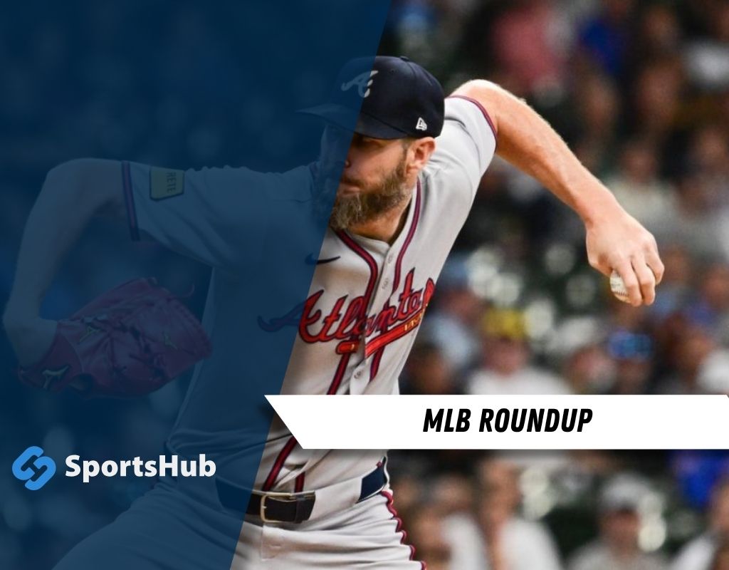 A baseball pitcher in a gray Atlanta Braves uniform winds up to throw during a game, with fans visible in the blurred background.