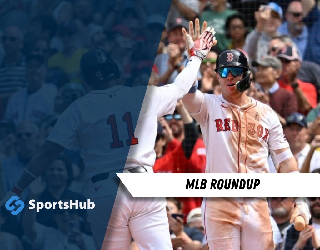 A Boston Red Sox player celebrates with teammates after a successful play, amid an enthusiastic crowd at a baseball game.