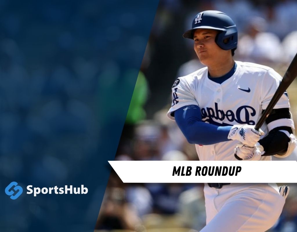A baseball player in a Dodgers uniform swings a bat, preparing to hit, with a blurred crowd in the background.