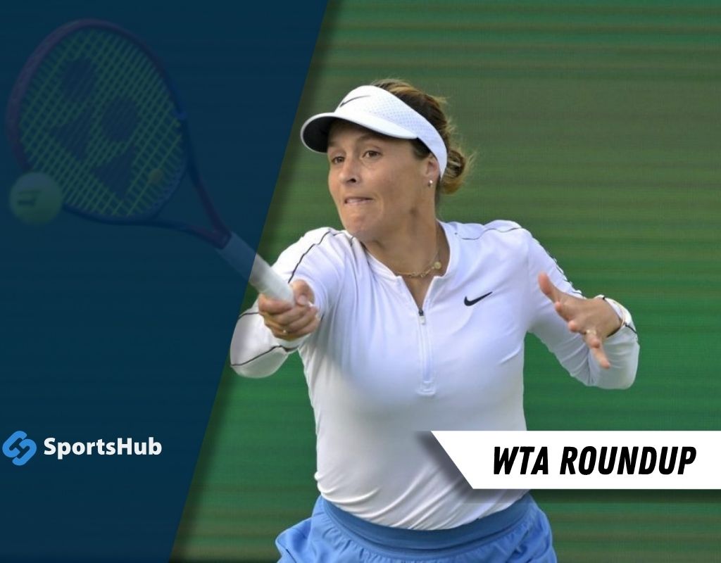 A tennis player prepares to hit a forehand shot on the court, wearing a white long-sleeve top and a visor, with a racket in hand.