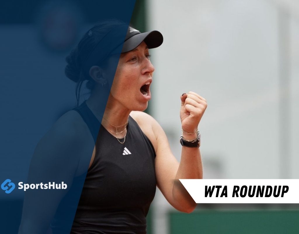 A female tennis player celebrates with a raised fist, wearing a black tank top and a cap